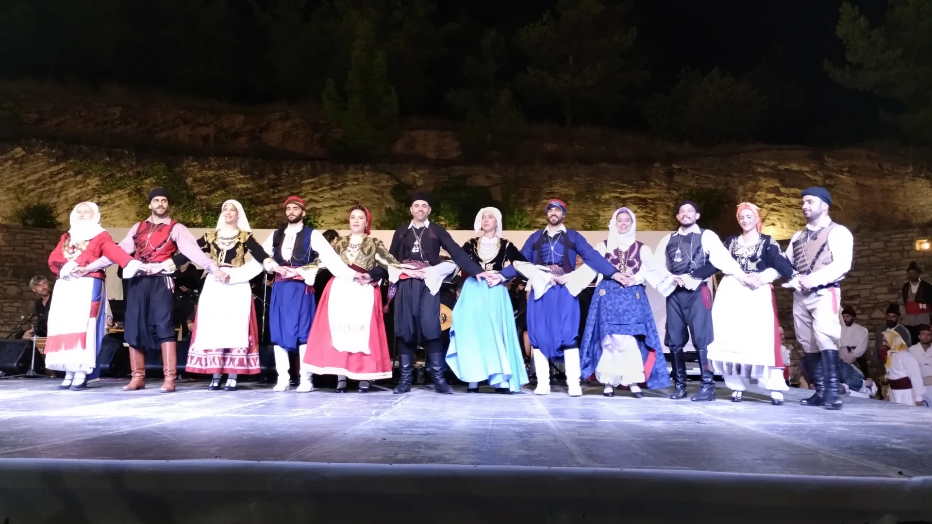 Dancers in traditional Greek regional costume performing an evening folk dance